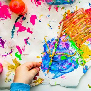 Stock image of child playing with colorful paints.