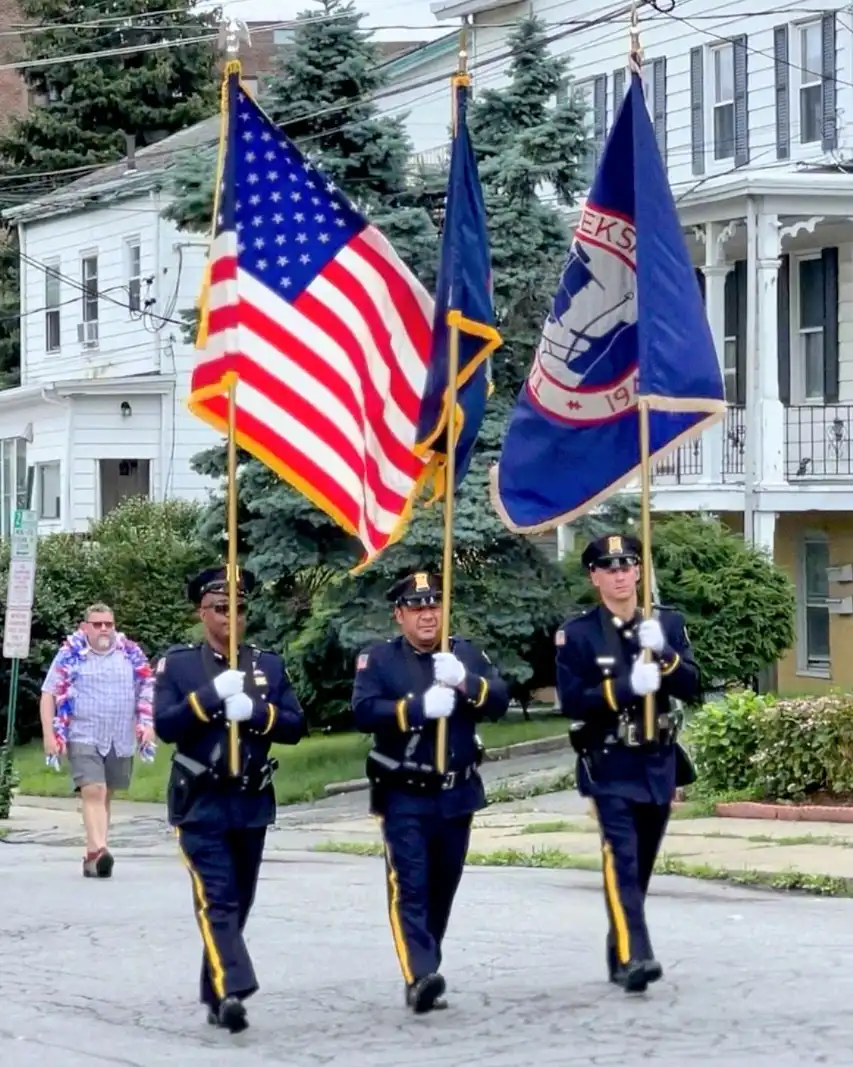 Marchers holding flags lead the Peekskill July 4th Parade
