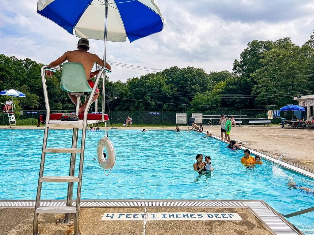 The Peekskill pool in Depew Park on an overcast day. A lifeguard sits in the foreground.