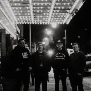 Black and white photo of the band Sound of a Smirk posing under the marquee of The Paramount in Peekskill