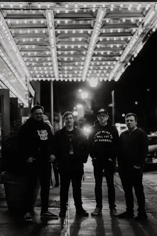 Black and white photo of the band Sound of a Smirk posing under the marquee of The Paramount in Peekskill