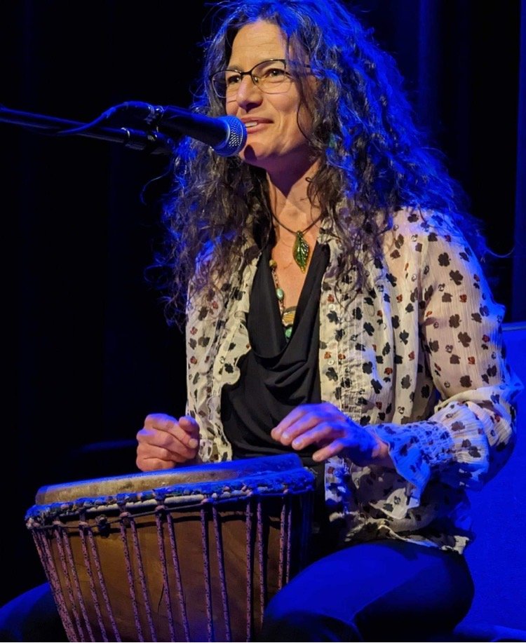 Tina Greenblat playing a drum on stage.
