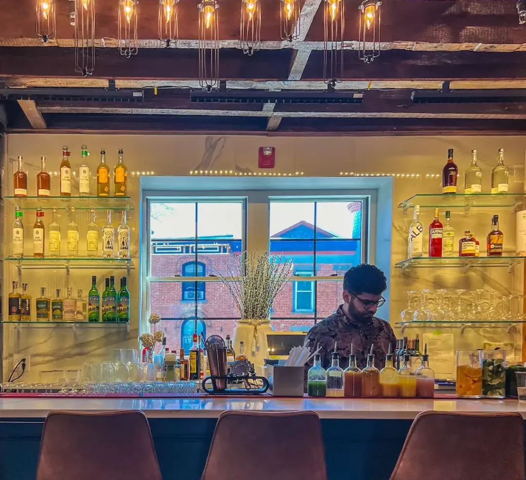 Bartender at Taco District with the rooftops of Downtown Peekskill framed in the background